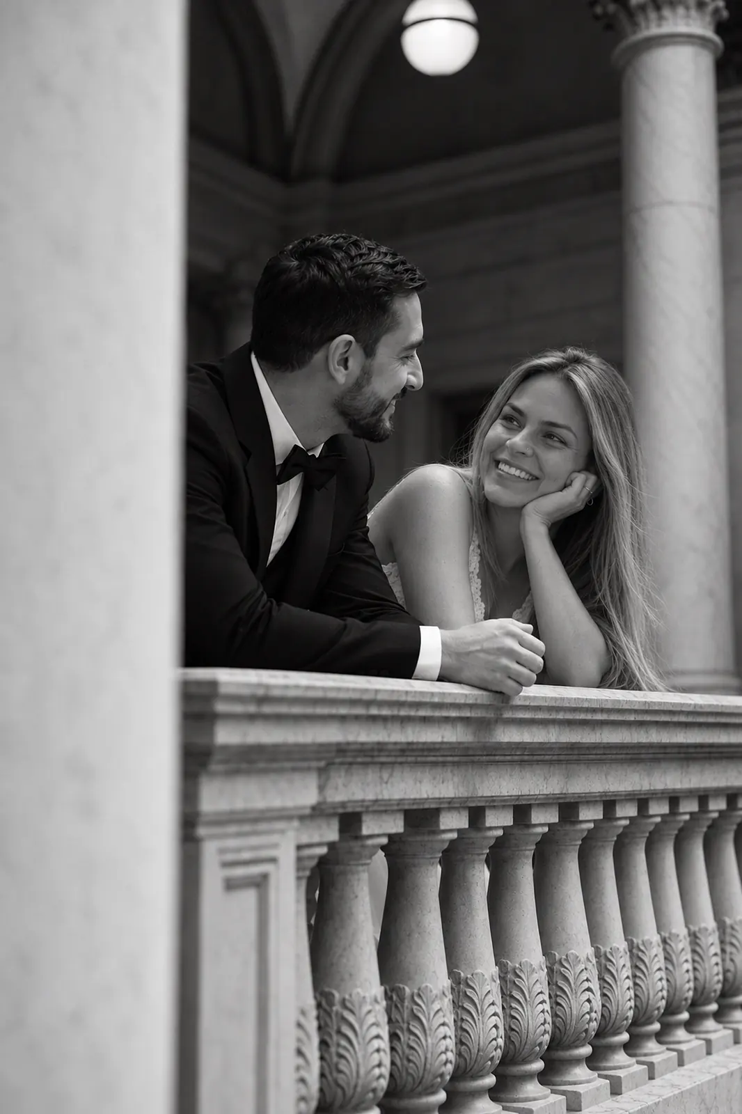 Juan Camilo y María Camila se miran apoyados en un balcón, en blanco y negro
