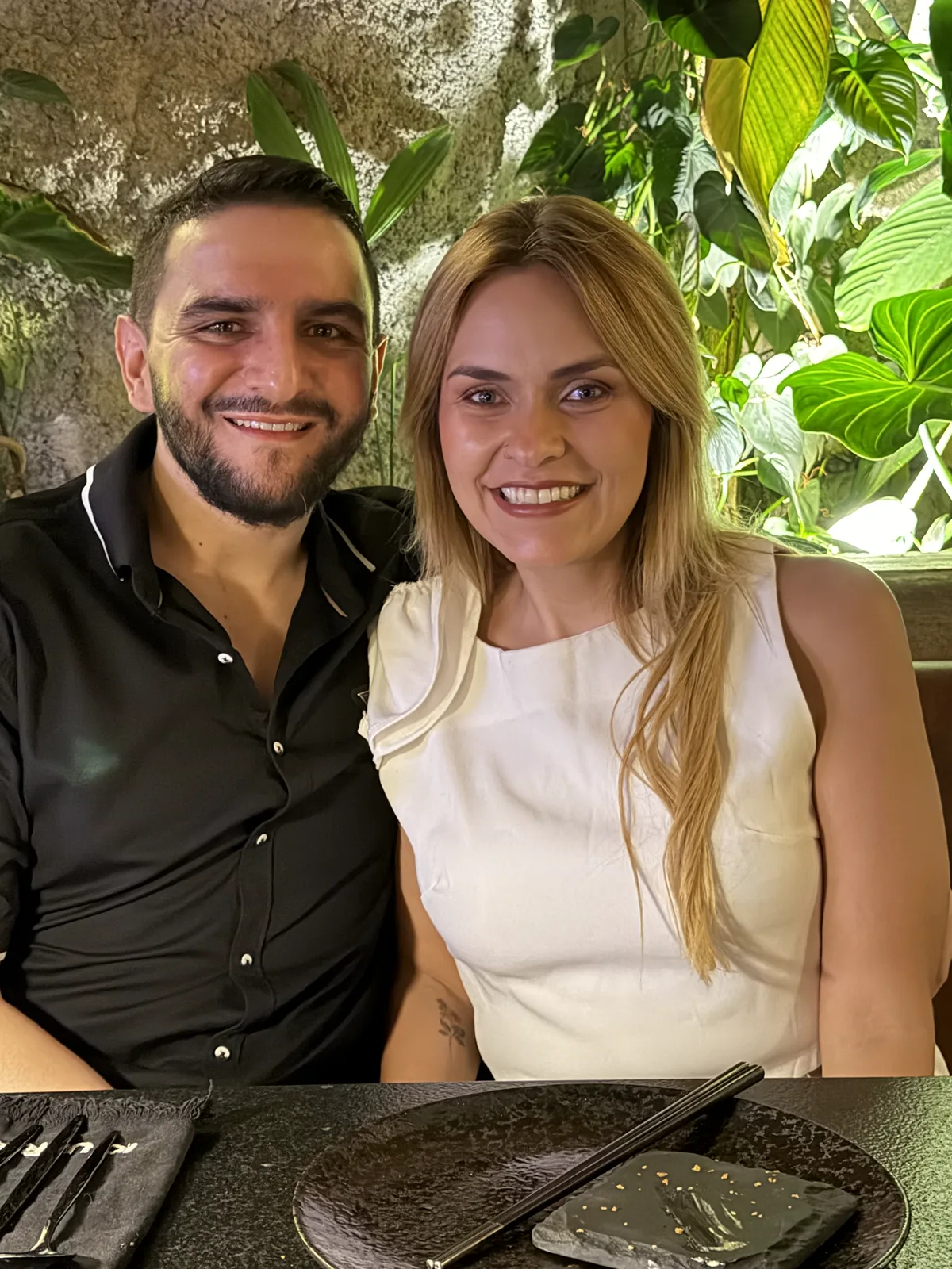 Juan Camilo y María Camila sonríen en una selfi rodeados de plantas